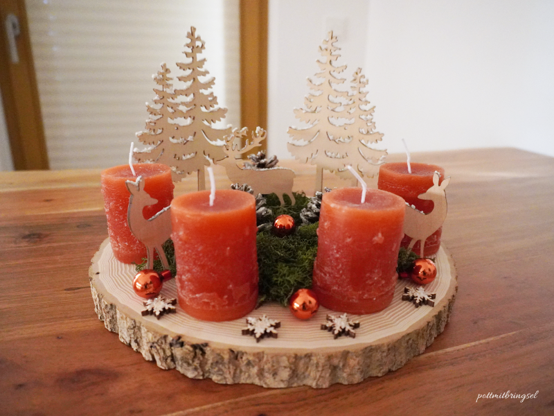 selbstgemachter Adventskranz mit Baumscheibe, Holzfiguren, Tannenzapfen, Moos, Weihnachtskugeln, Kunstschnee und selbstgegossenen Kerzen