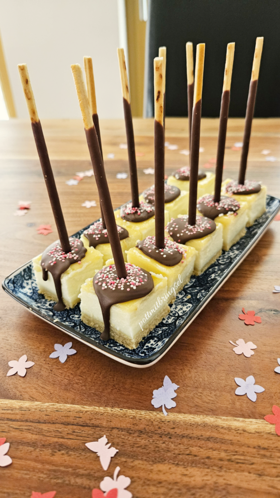 Schoko-Käsekuchensticks aus Tiefkühlkäsekuchen mit Schokolade, bunten Streuseln und Schokoladen Mikado Sticks